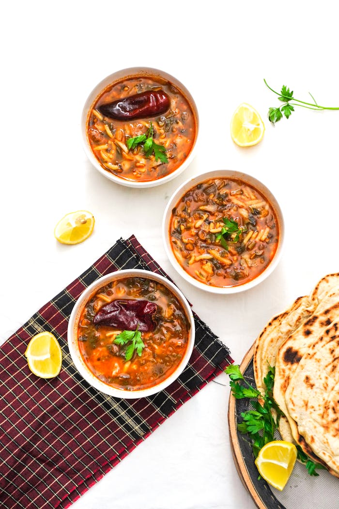 Crafting Captivating Headlines: Your awesome post title goes here Tasty Moroccan Harira soup bowls with herbs, lemon slices, and fresh flatbread for a flavorful meal.