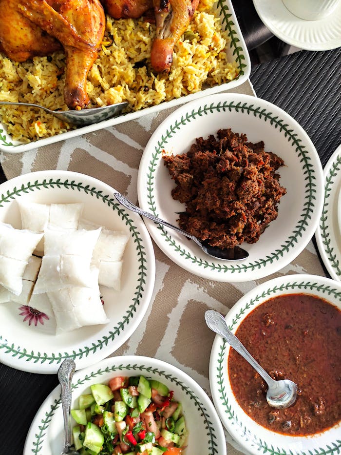 Mastering the First Impression: Your intriguing post title goes here Top view of a vibrant African meal featuring chicken, rice, salad, and sauces in ceramic bowls.